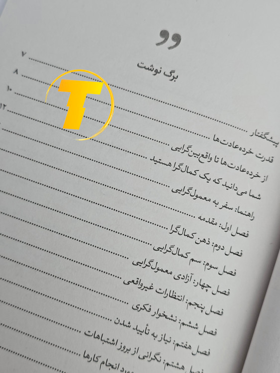 صفحات باز کتاب چگونه کمالگرا نباشیم – نمایی از چاپ تمیز، صفحهآرایی منظم روی میز سفید