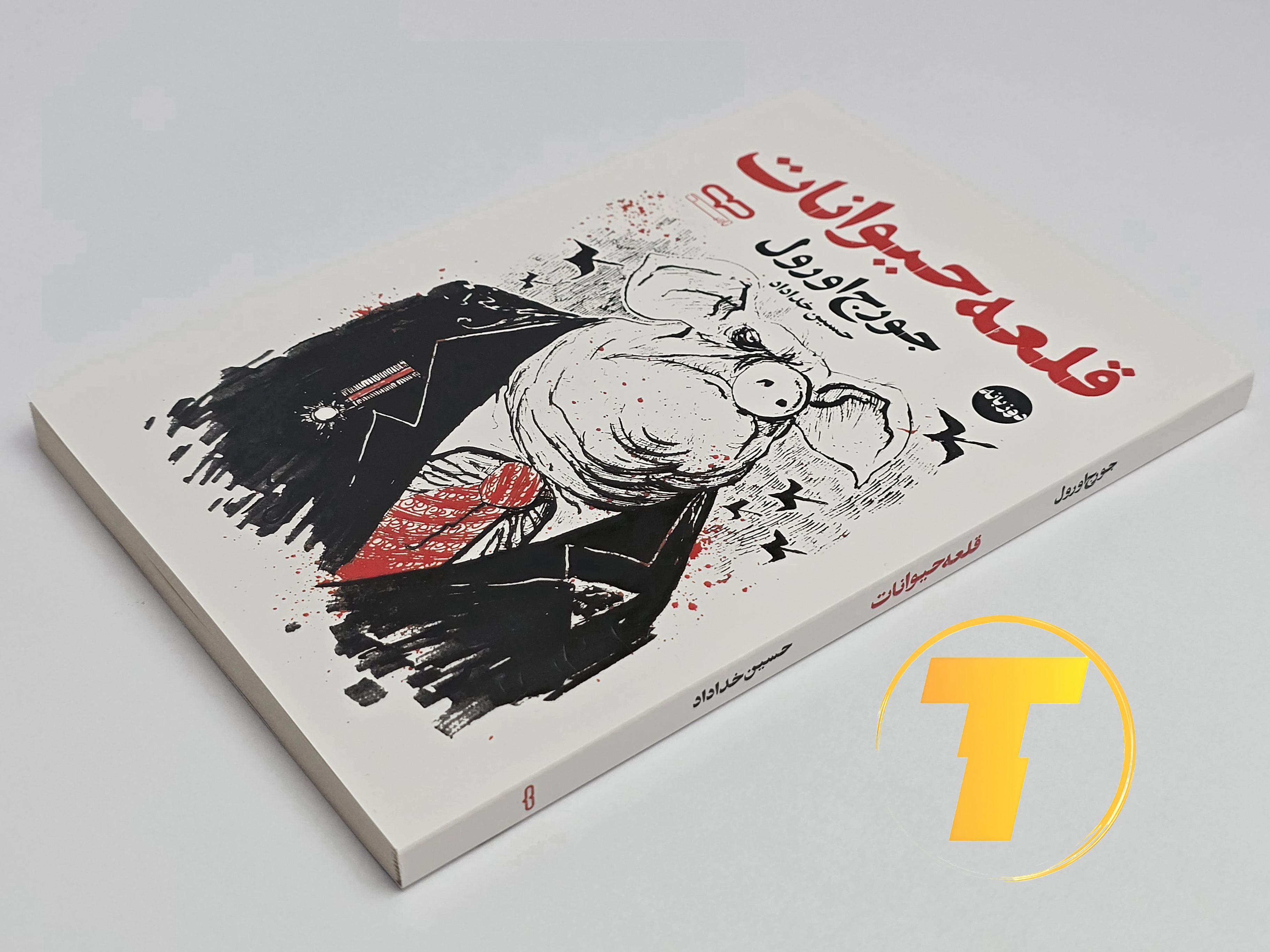 کتاب قلعه حیوانات روی میز سفید – تصویری از جلد و کناره‌های کتاب چاپ‌شده توسط نشر آثار نور