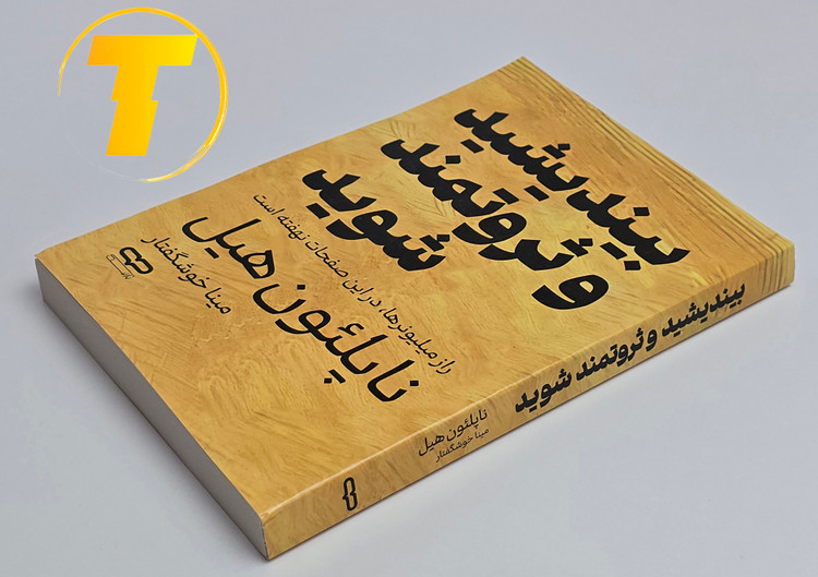 کتاب بیندیشید و ثروتمند شوید روی میز سفید – تصویری از جلد و کنارههای کتاب چاپشده توسط نشر یارنیک