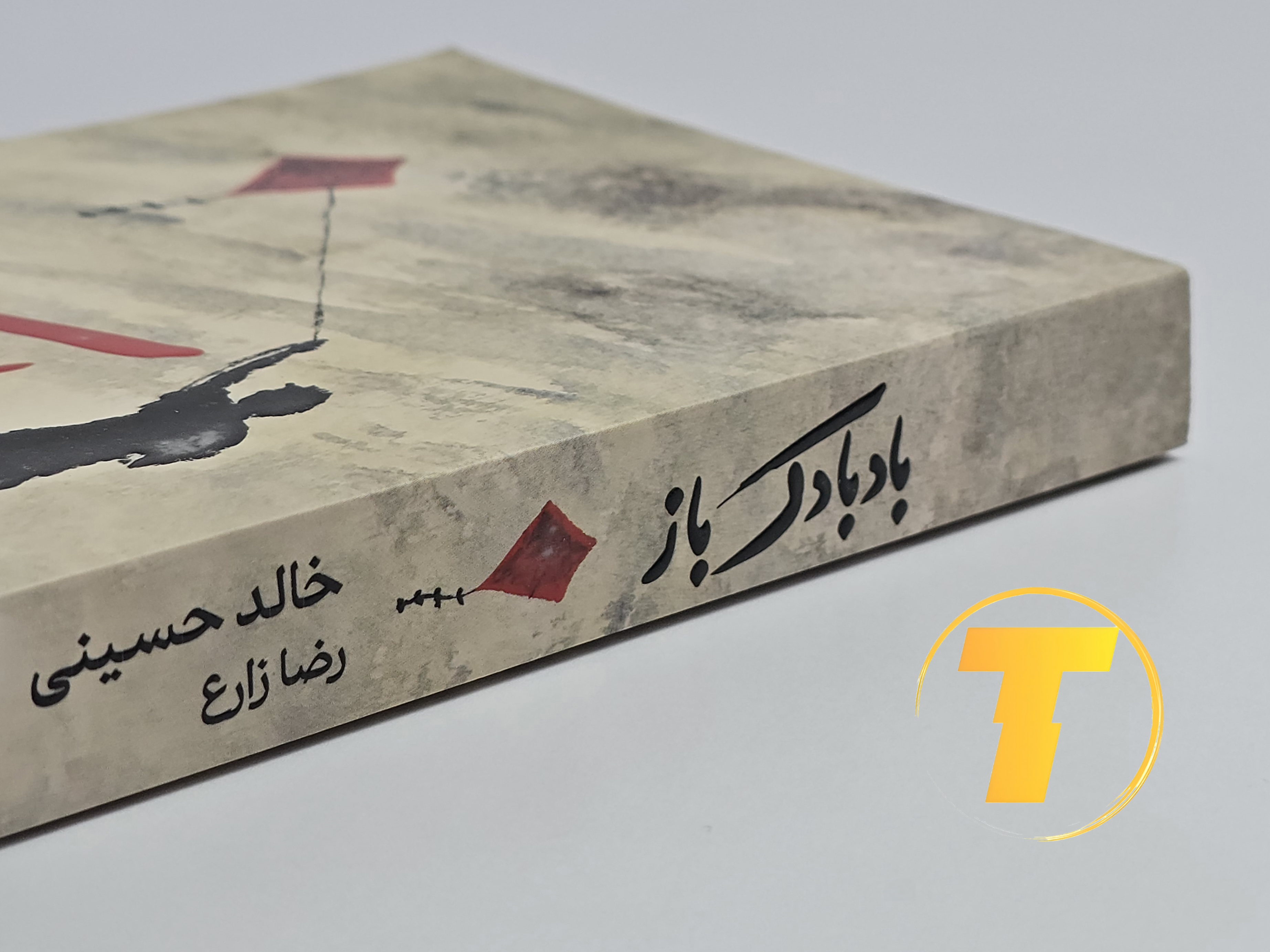 جزئیات جلد شومیز کتاب بادبادک‌باز با روکش یووی برجسته و طراحی حرفه‌ای نشر آثار نور