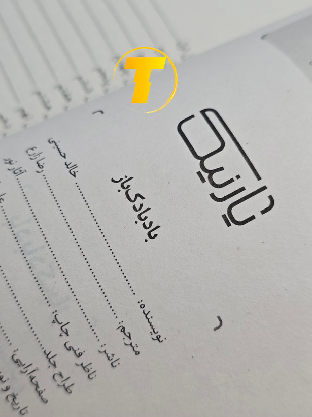 صفحات باز کتاب بادبادکباز – نمایی از چاپ تمیز، صفحهآرایی منظم و طراحی نشر آثار نور روی میز سفید