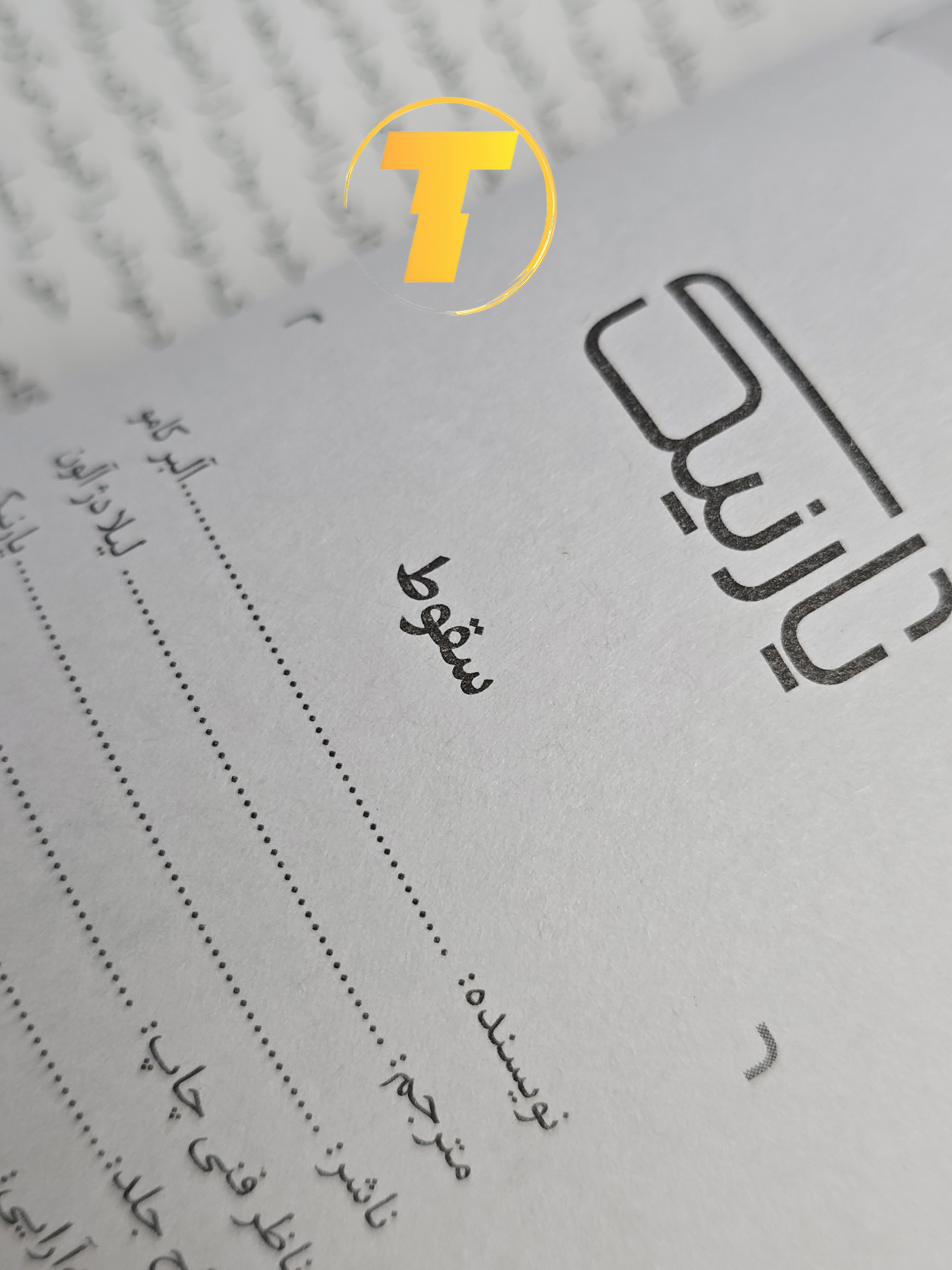 تصویر کتاب سقوط در کنار لوازم تحریر و مطالعه