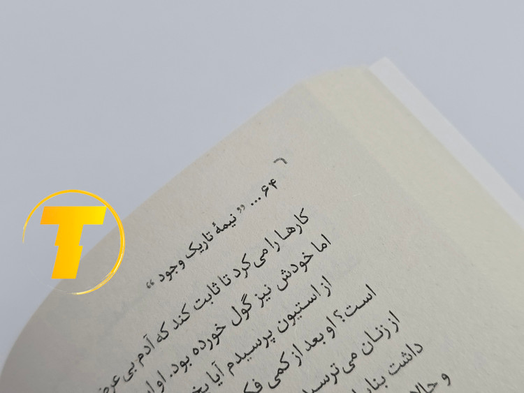 صفحات باز کتاب نیمه تاریک وجود – نمایی از چاپ تمیز، صفحهآرایی منظم و طراحی نشر یارنیک روی میز سفید