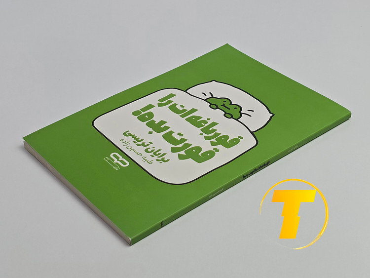 کتاب قورباغهات را قورت بده روی میز سفید – تصویری از جلد و کنارههای کتاب چاپشده توسط نشر یارنیک