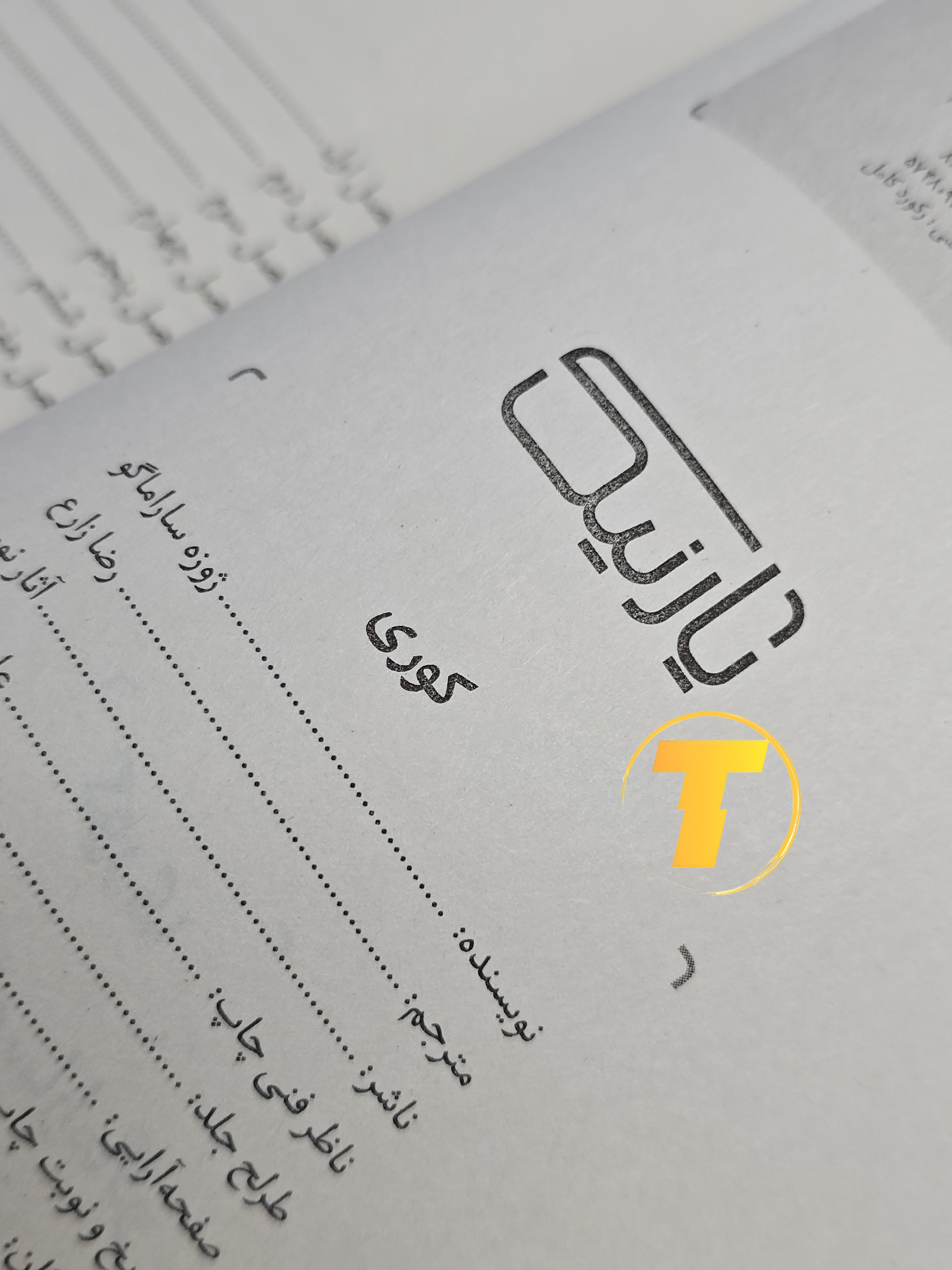 صفحات باز کتاب کوری – نمایی از چاپ تمیز، فونت خوانا و صفحه‌آرایی دقیق نشر آثار نور روی میز سفید