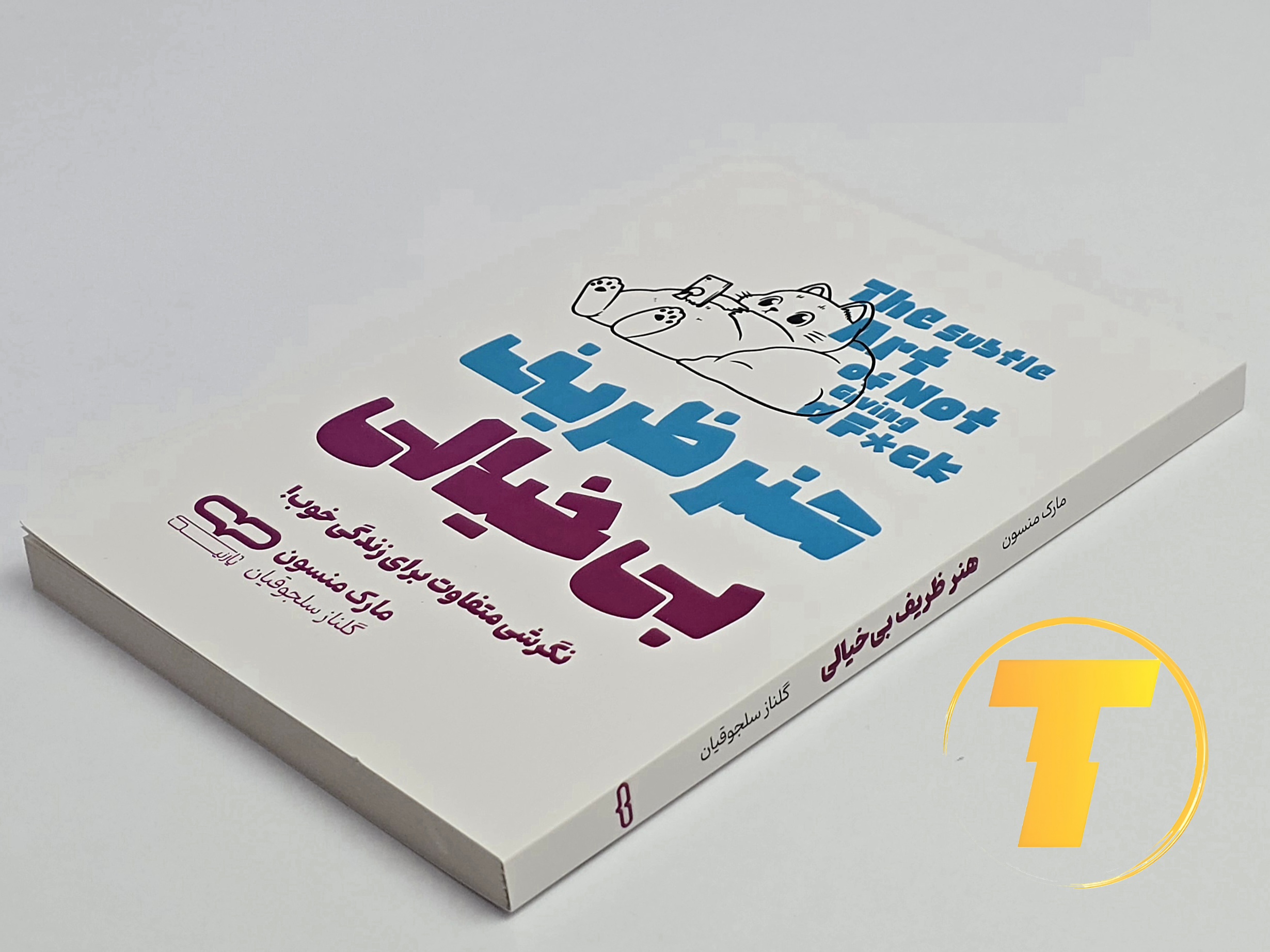 کتاب هنر ظریف بی‌خیالی روی میز سفید – نمایی از جلد و لبه‌های کتاب چاپ‌شده توسط نشر یارنیک