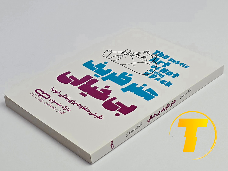 کتاب هنر ظریف بیخیالی روی میز سفید – نمایی از جلد و لبههای کتاب چاپشده توسط نشر یارنیک