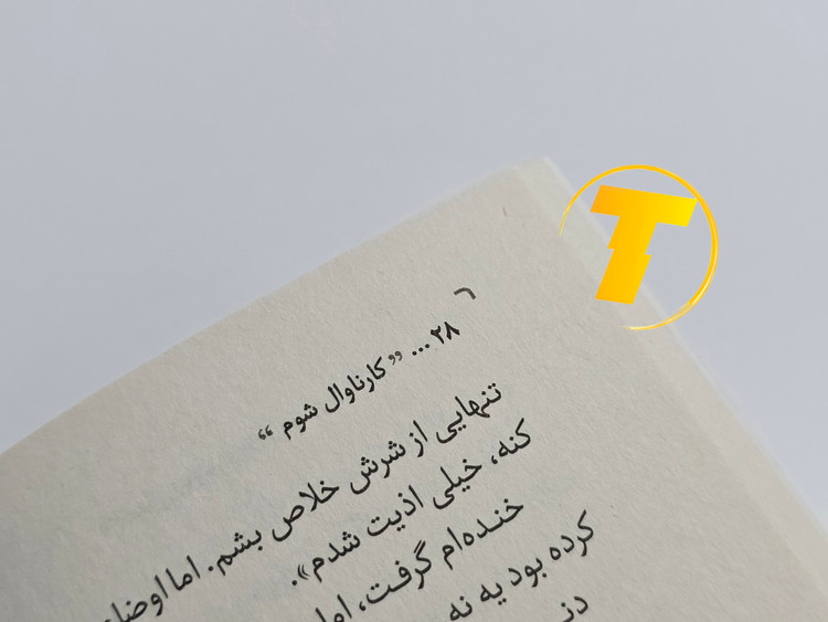 صفحات باز کتاب کارناوال شوم – نمایی از چاپ تمیز، صفحهآرایی منظم و طراحی انتشارات یارنیک روی میز سفید