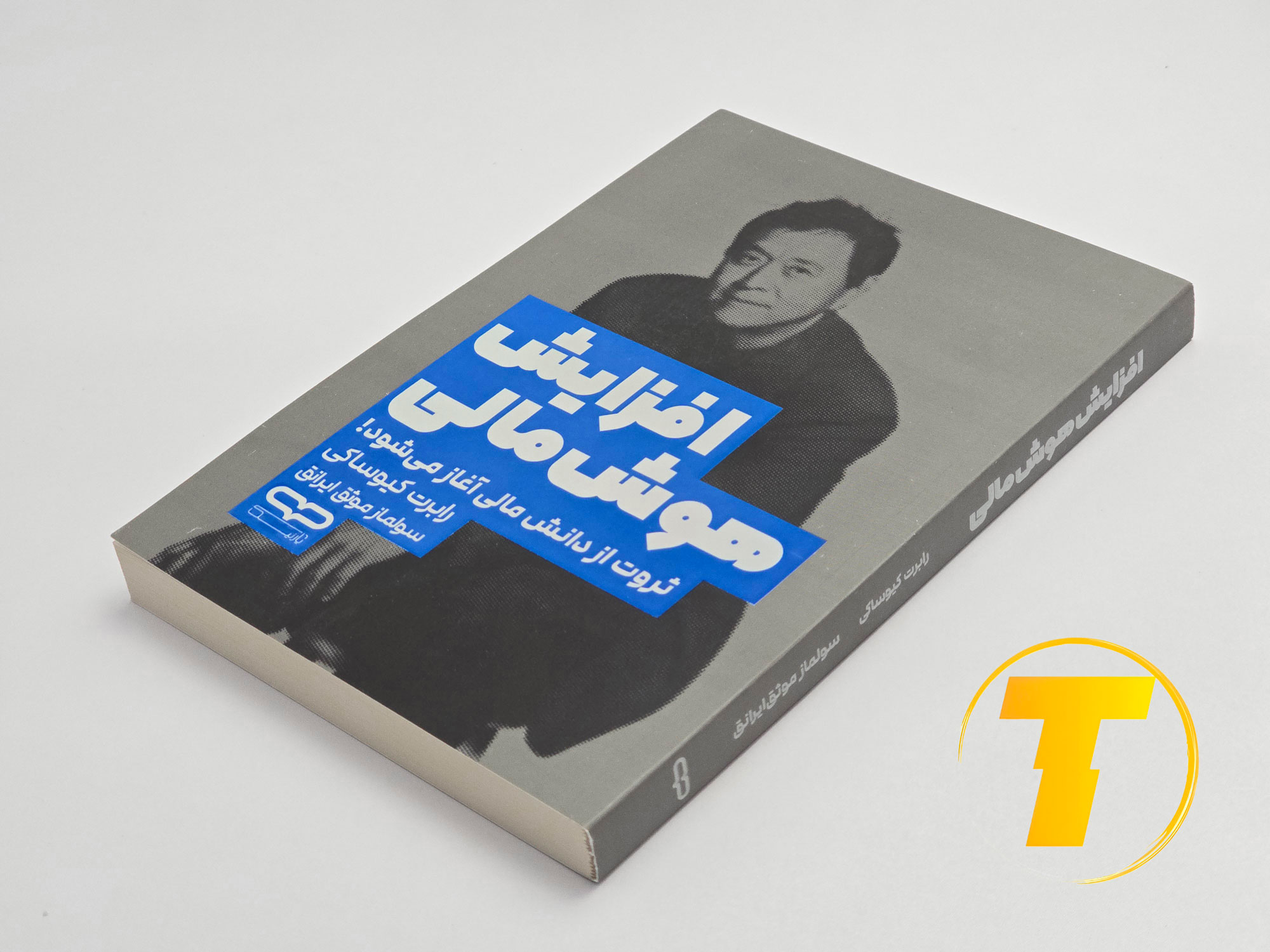 کتاب افزایش هوش مالی روی میز سفید – تصویری از جلد و کناره‌های کتاب چاپ‌شده توسط نشر یارنیک