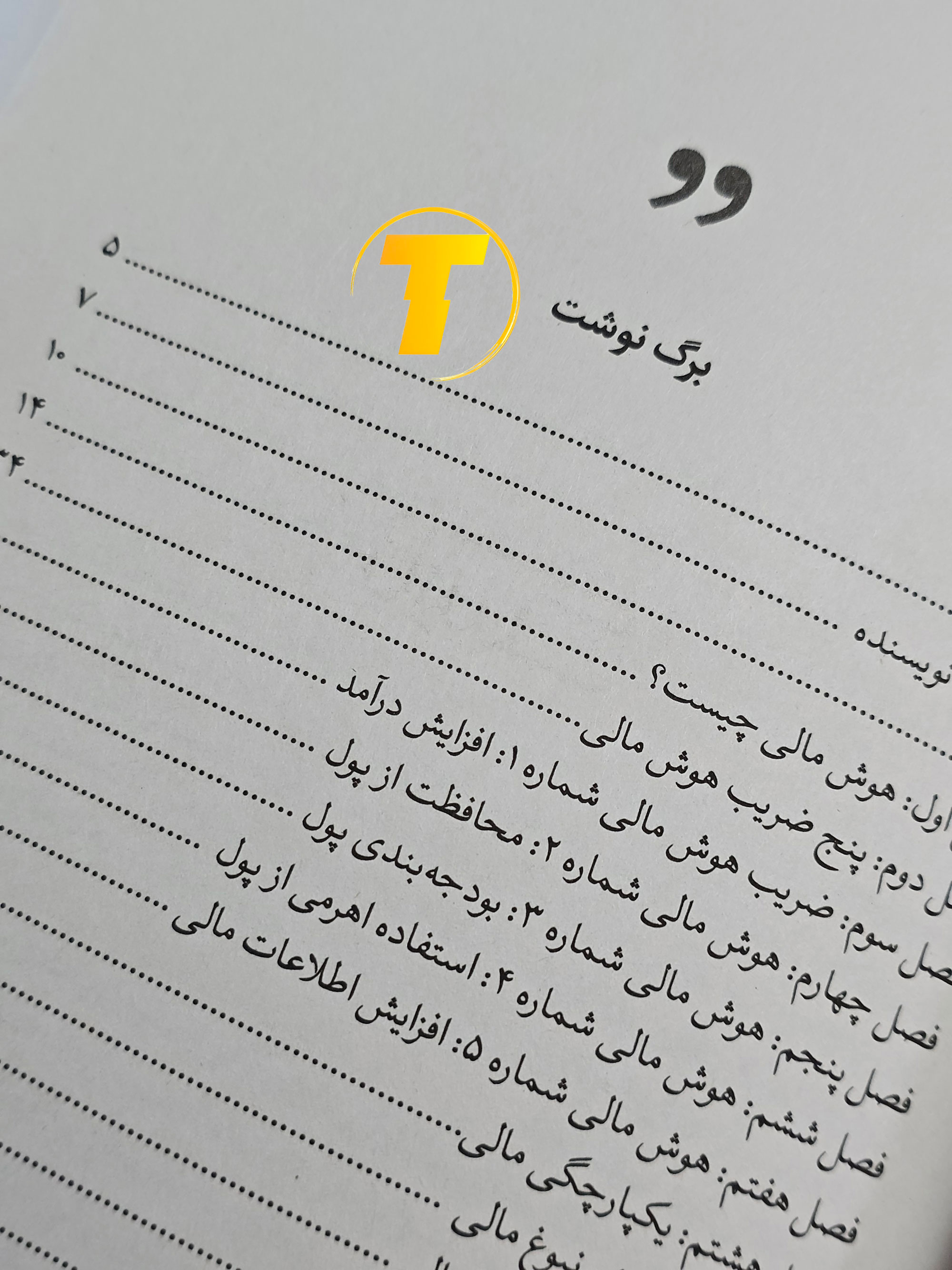 صفحات باز کتاب افزایش هوش مالی – نمایی از چاپ تمیز، صفحه‌آرایی منظم و طراحی نشر یارنیک روی میز سفید