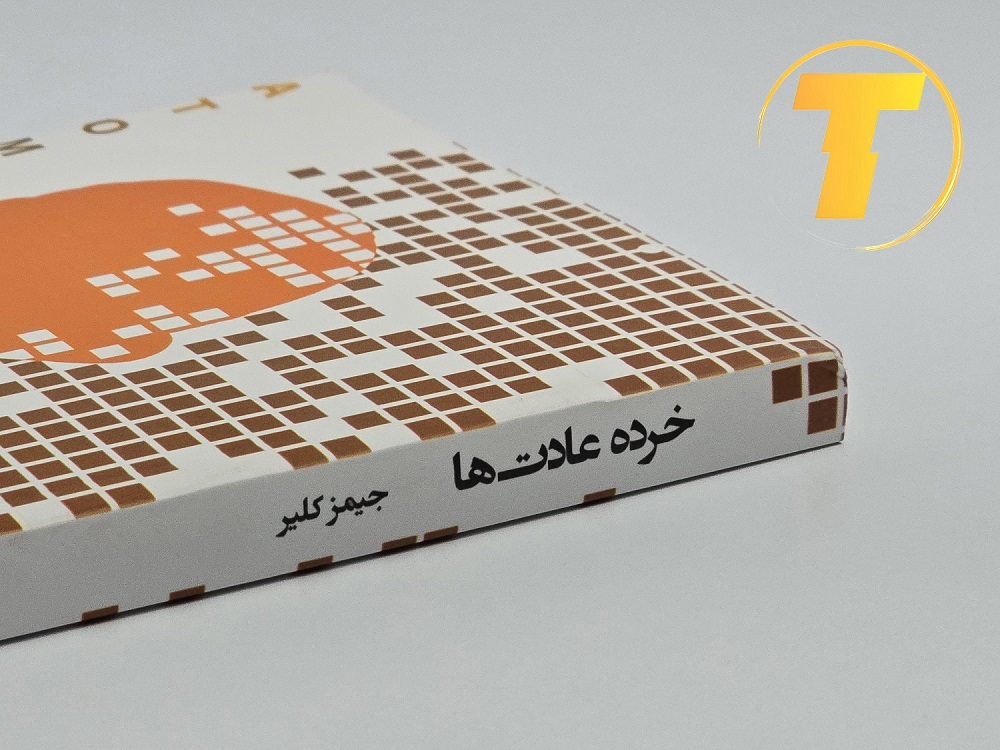 نمای نزدیک از جلد شومیز کتاب «خرده عادتها» با بافت مات و برجسته در ناحیه عنوان. کیفیت چاپ بالا و رنگبندی سفید و طلایی.