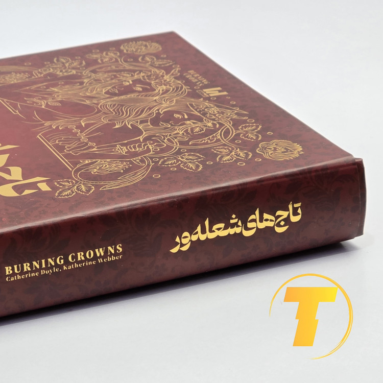 نمای کتاب تاجهای شعلهور روی میز مطالعه